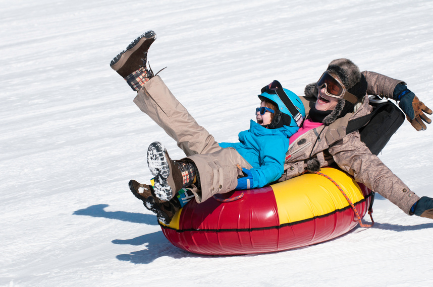 a man and a child on a snow tube