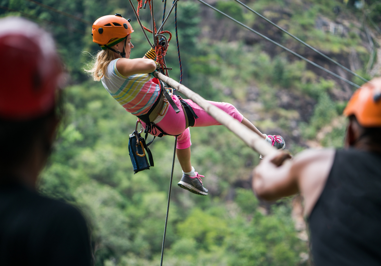 a woman on a zipline in the mountains