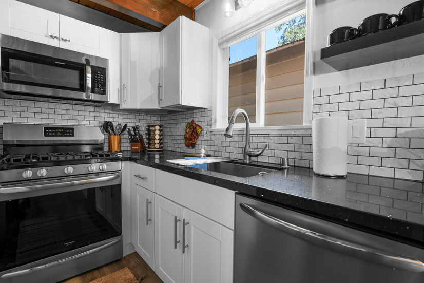 The kitchen showcases the microwave, the stove, and the cooktop, along with extra countertop space and a sink.